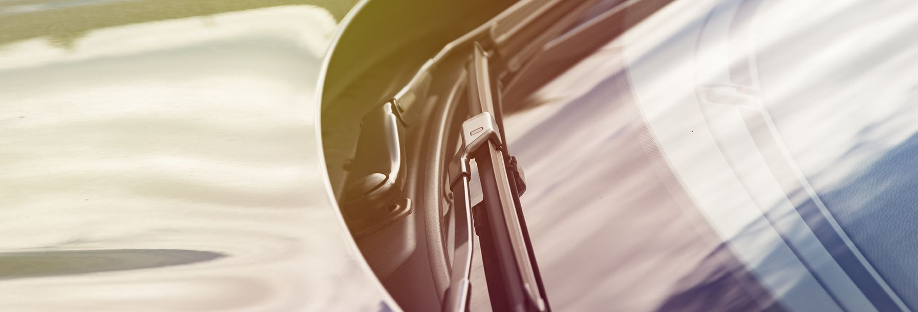 Man examining windscreen wiper blades on automobile.