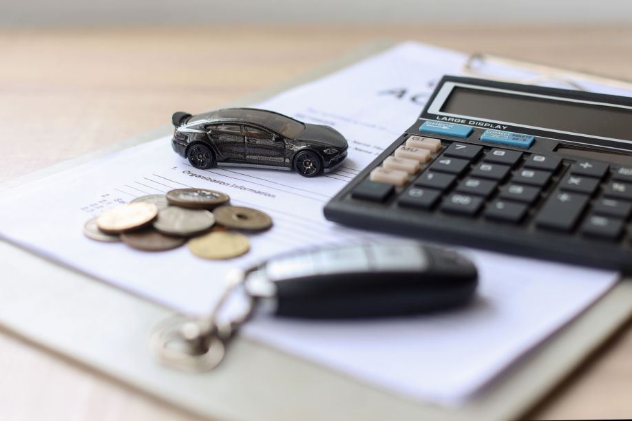 Car key with notebook calculator and pocket money on table